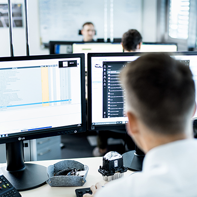 Mitarbeiter einer Werkstatt kalkuliert mit der DAT-Software die Reparaturkosten eines Fahrzeugs