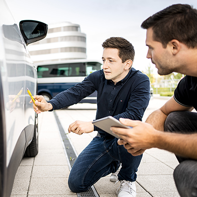Zwei Autohaus Mitarbeiter begutachten ein Fahrzeug und bewerten dieses mit der Bewertungssoftware SilverDAT