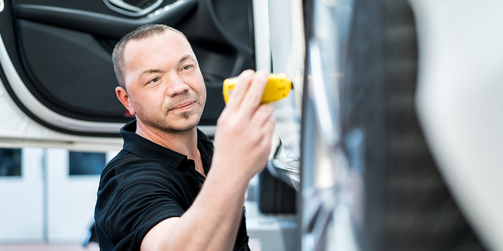 DAT Expert Partner misst die Lackdicke an einem Fahrzeug für das ein Gutachten erstellt wird