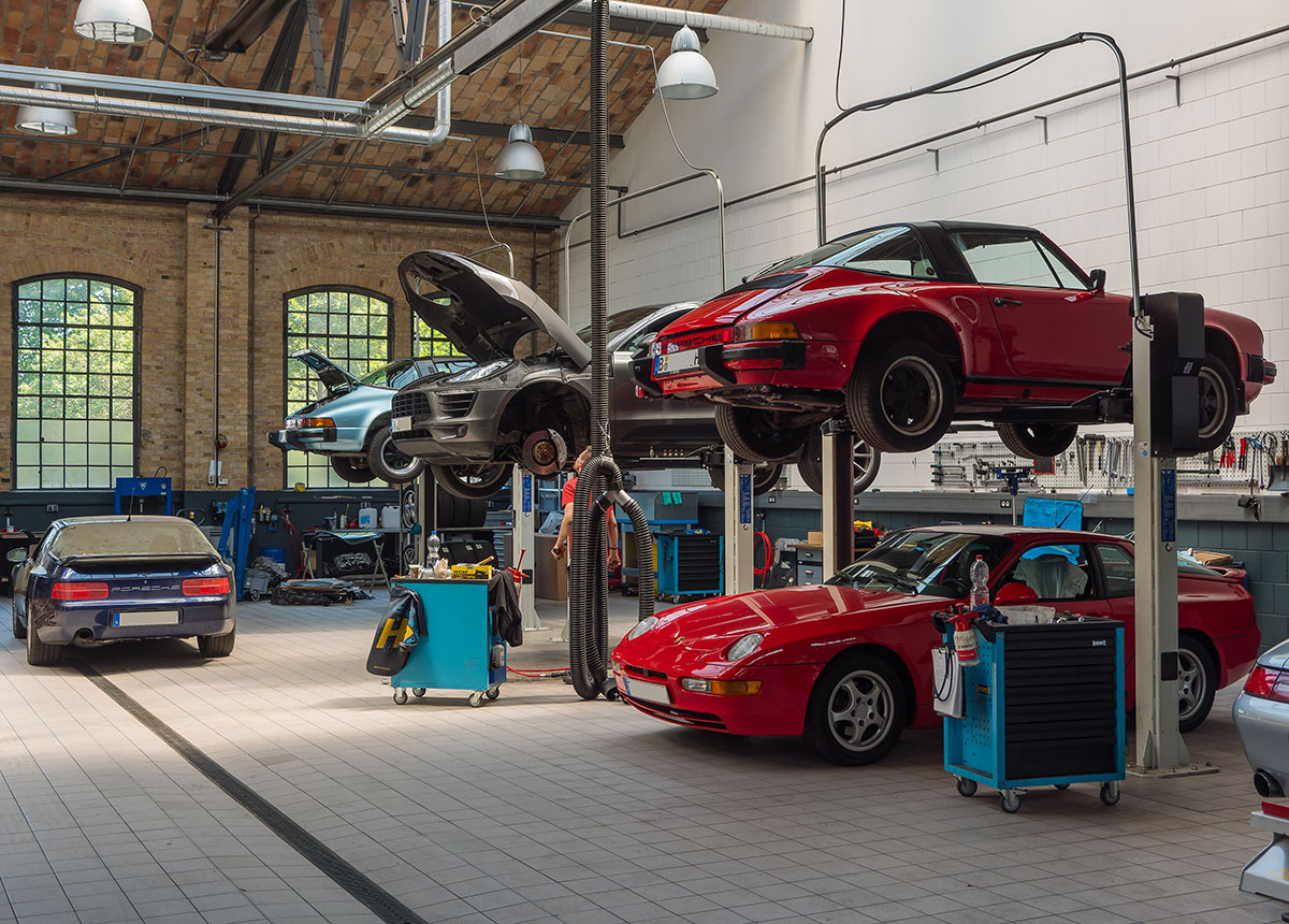 Autowerkstatt mit mehreren Porsche-Fahrzeugen (auch Oldtimer und Youngtimer), auch auf Hebebühnen