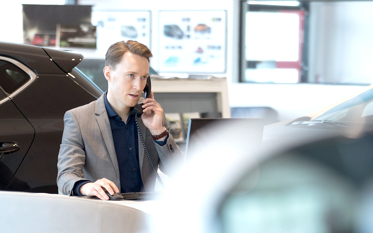 Verkäufer im Autohaus-Showroom: SilverDAT 3 hat seinen festen Platz in Automobil-Betrieben und Werkstätten. Dank umfangreicher Software-Schnittstellen zu den geläufigsten DMS (Dealer Management Systemen) lässt sich SilverDAT 3 in Software-Systeme einbinden. 