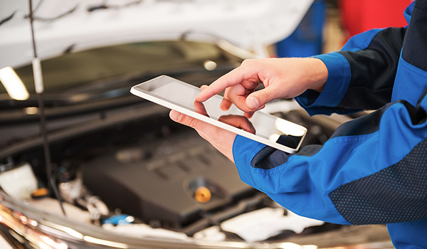Kfz-Gutachter nutzt die mobile App von SilverDAT 3 Expert Partner vor einem Fahrzeug bei dem der Zustand bewertet wird