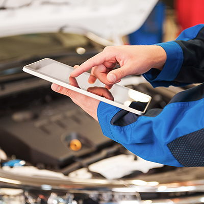 Autohausmitarbeiter mit Tablet vor einem Auto. Fahrzeugbewertung mit SilverDAT 3