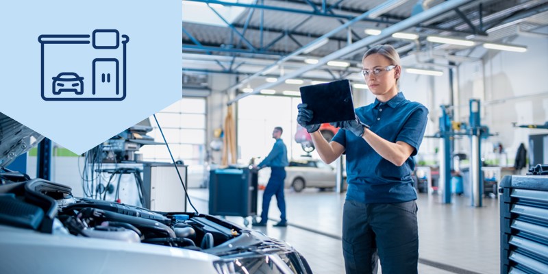 Frau mit Tablet-PC vor einem Auto kalkuliert Reparaturkosten und bewertet das Fahrzeug mit SilverDAT, der Software für Autohändler