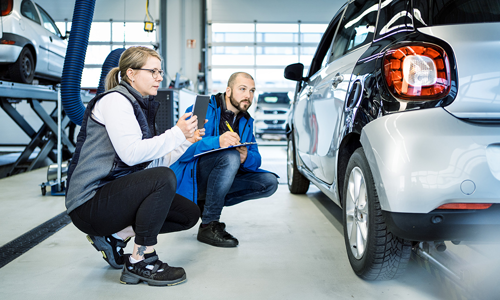 Servicemitarbeiter im Autohaus kalkulieren einen Schaden am Kotflügel mit der Software SilverDAT 